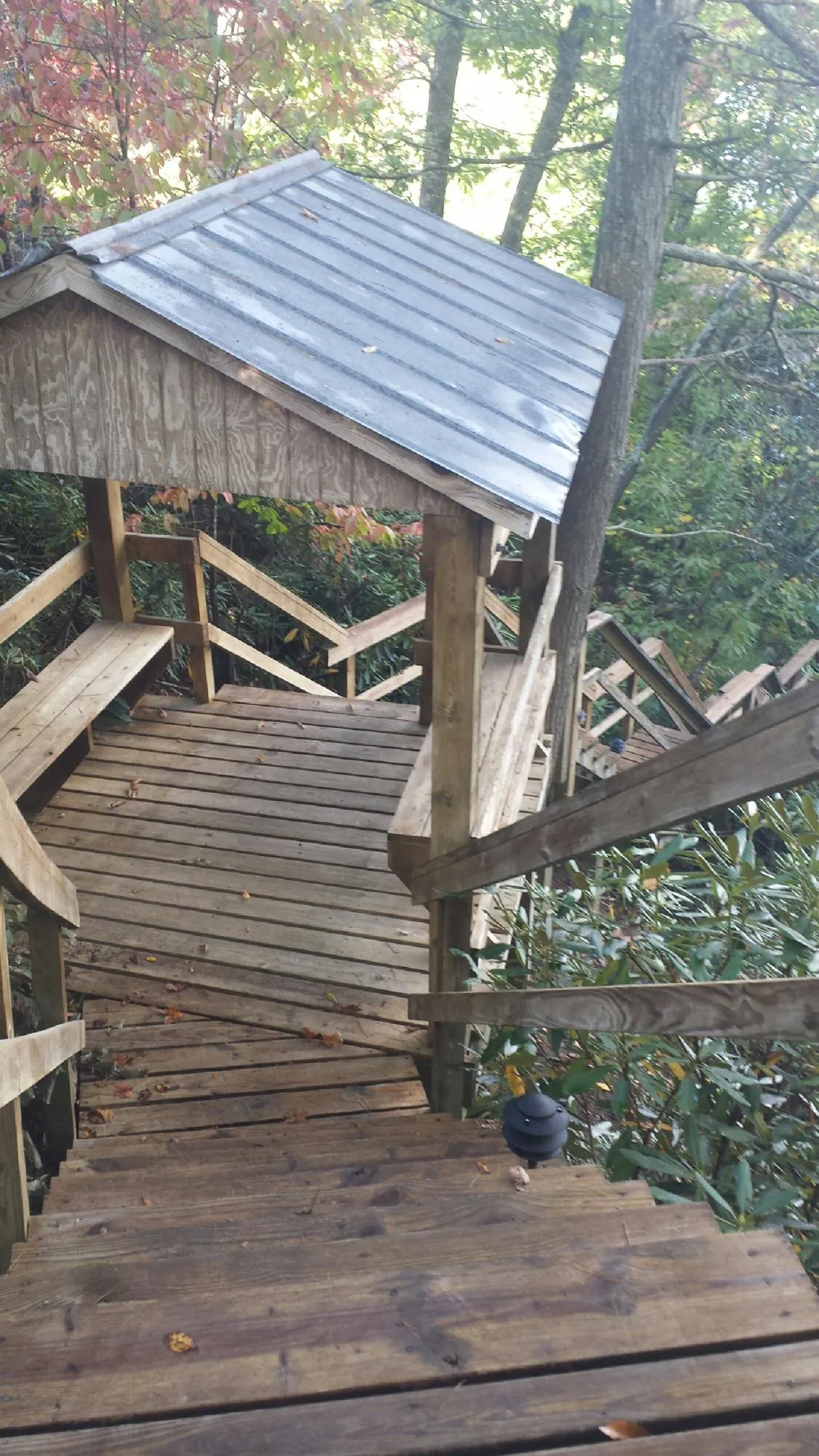 Metal roofed shelter over wooden steps on a wooded walkway — Skylight Repair & Installation work by our crew in Northboro