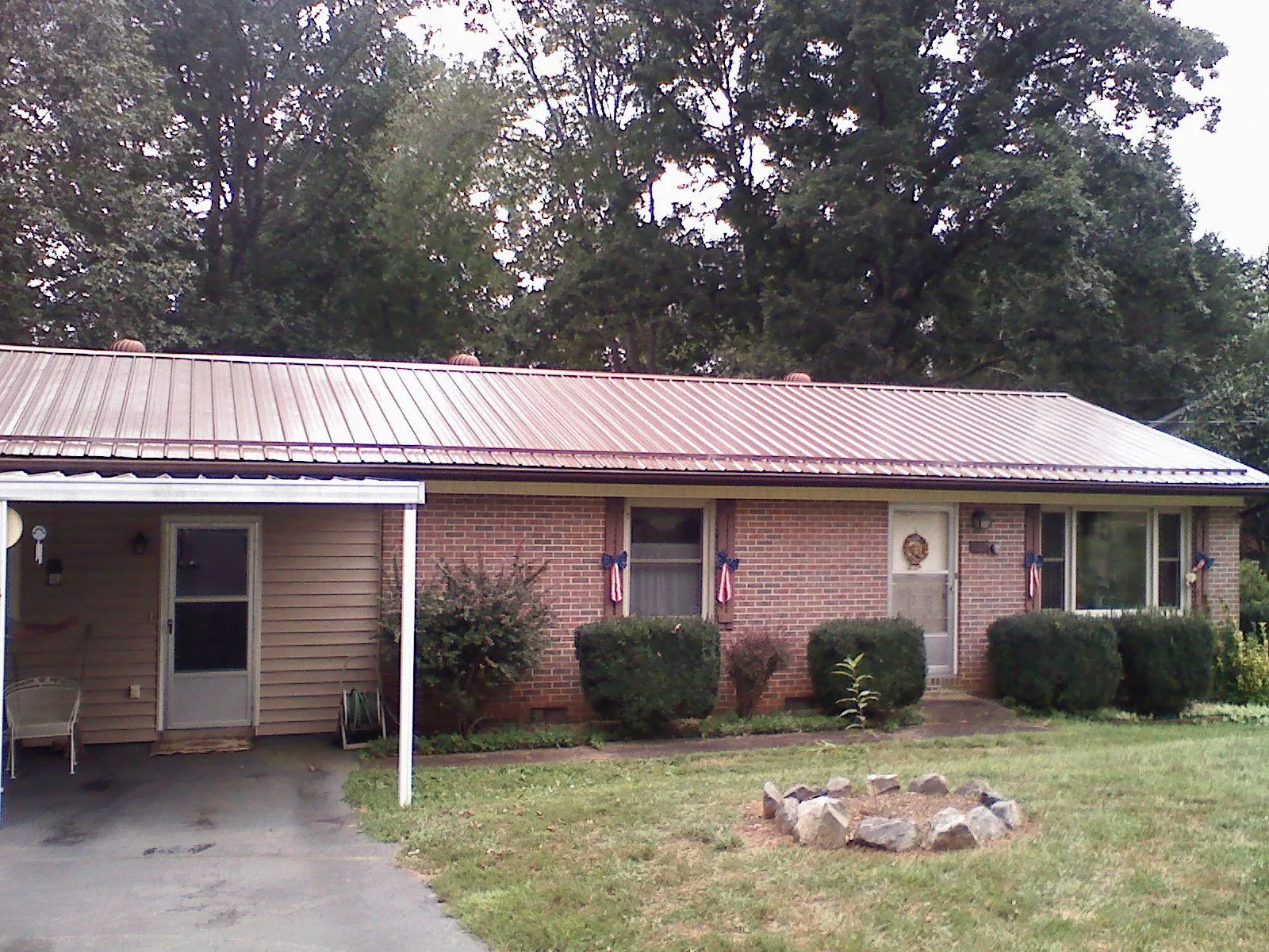 Bronze metal roof and carport on a brick ranch home — Roof Repair work by our crew in Northboro